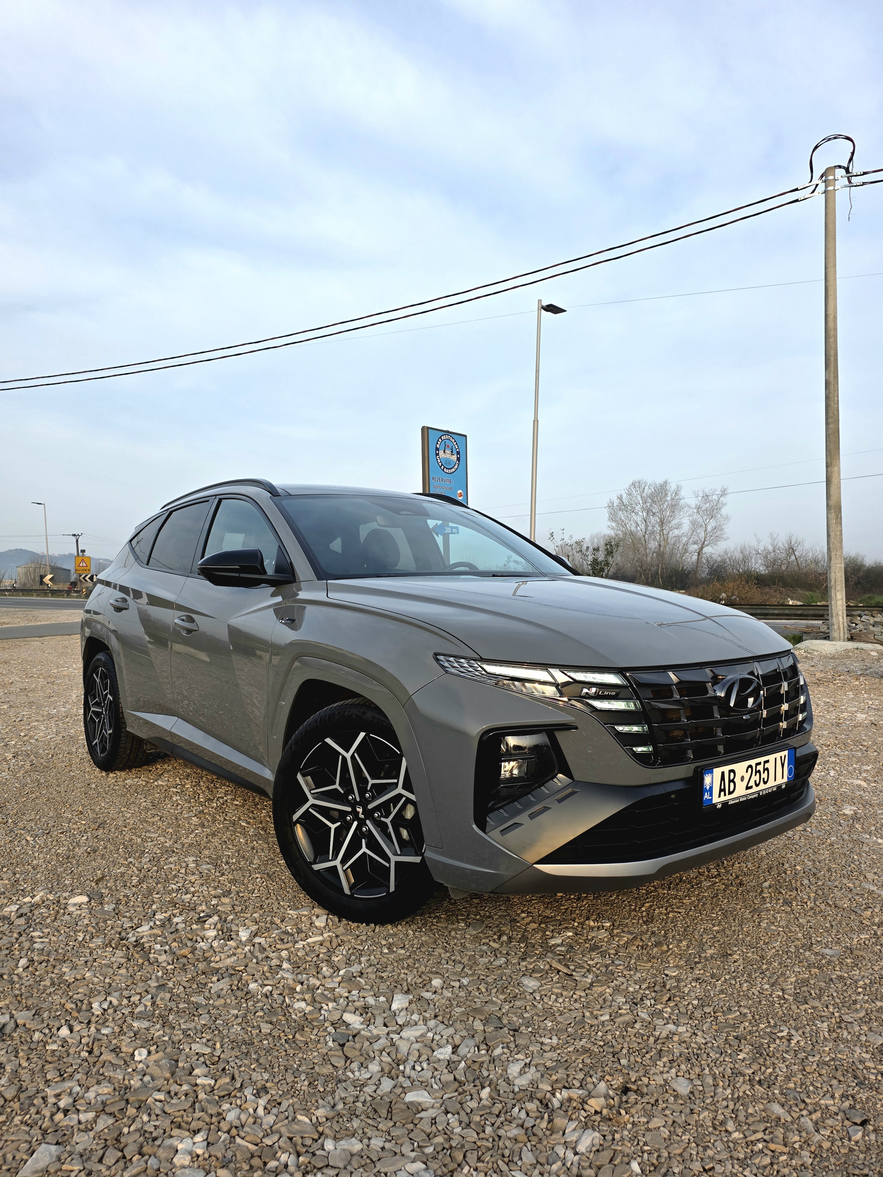Hyundai Tucson N-Line 1.6 CRDi MHEV Automatik AWD – Model 2023
📌 Kilometrazhi: 28.000 km
📌 Ngjyra: Phantom Black
📌 Blerë në koncesionarin zyrtar Hyundai Albania ne shkurt 2023
📌 Garanci deri në vitin 2028
Karakteristikat Teknike:
✔ Motorr: 1.6 CRDi Diesel + Mild Hybrid (Euro 6D)
✔ Fuqia: 136 HP
✔ Transmisioni: Automatik DCT (E-Shift By Wire)
✔ Tërheqje: AWD (4x4)
🛠 Pajisjet Kryesore dhe Opsionet Shtesë:
🔹 Komoditet & Brendësi Premium:
✅ Sedilje lëkurë/kamosh N-Line me qepje sportive të kuqe
✅ Sedilje me komandim elektrik (sedilja e shoferit me memorie)
✅ Ngrohje & ftohje për sediljet e përparme
✅ Ngrohje për sediljet e pasme
✅ Suport lumbar për sediljen e shoferit
✅ Timon sportiv i veshur me lëkurë, me ngrohje
✅ Tavani me veshje të zezë premium
✅ Klimatizator automatik me 3 zona
🔹 Teknologji & Siguri e Avancuar:
✅ Ekran dixhital 10.25” me navigacion, Bluetooth, Apple CarPlay & Android Auto
✅ Sistem audio premium Krell
✅ Karikim wireless për smartphone
✅ Smart Cruise Control (Stop & Go)
✅ Drive Mode Select (mënyra të ndryshme drejtimi)
✅ Blind Spot Collision Avoidance Assist
✅ Lane Keeping Assist & Lane Following Assist
✅ Forward Collision Avoidance Assist
✅ Highway Assist
✅ Sensore parkimi para & prapa
✅ Kamera parkimi 360°
✅ Bagazh me hapje/mbyllje automatike
✅ Perde për xhamat e pasëm
🔹 Eksterier Sportiv & Performancë:
✅ Bodykit sportiv N-Line
✅ Disqe alumini 19” me goma Continental
✅ Fenerë të përparme Full LED & DRL LED
✅ Xhamat e pasëm të zinj (privatësi)
✅ Shina në tavan
✅ Pasqyrat me palosje elektrike dhe ngrohje